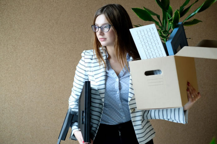 young business woman holding a box and quiet quitting