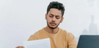 Online Document Verification: Enhancing User Experience in Marketplace Man looking through documents at workplace