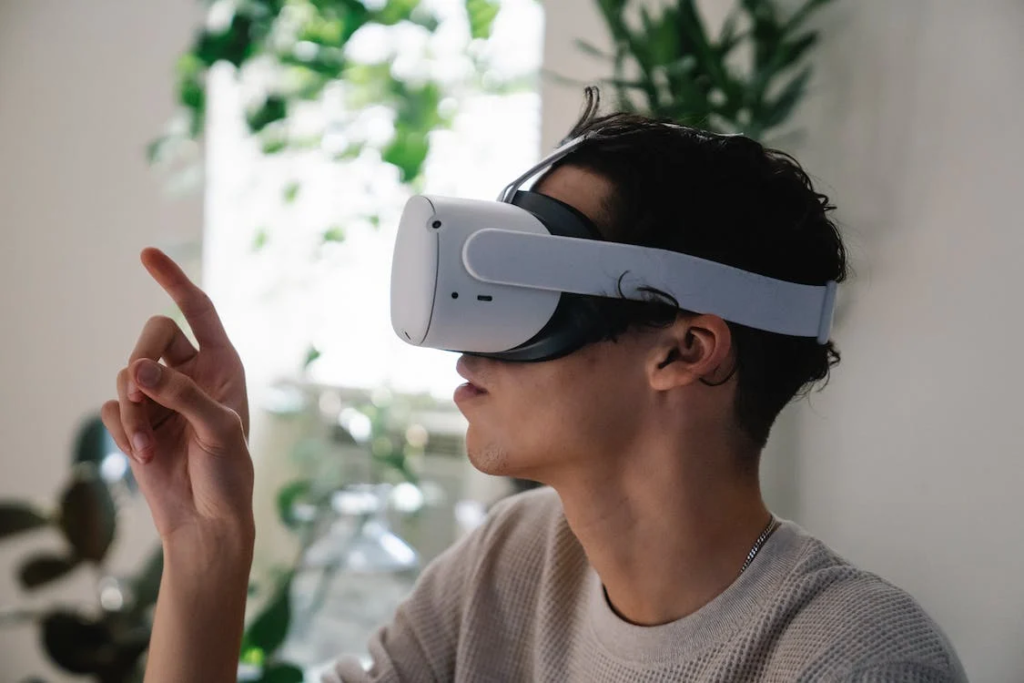 Young male millennial in VR goggles looking at finger
