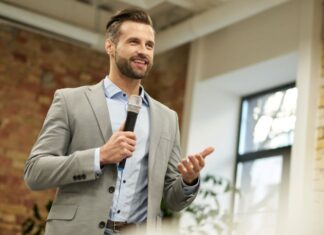 Volunteer Your Time and Expertise to Further Build Your Brand businessman with microphone speaking about how to volunteer your time and expertise