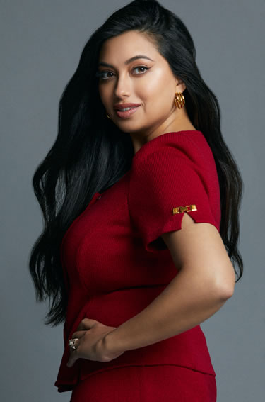 Shama Hyder in red dress turned sideways to face camera