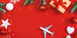 6 Ways to Ensure Network Security During Holiday Travel toy airplane on red holiday cover with Christmas holiday decorations for holiday travel