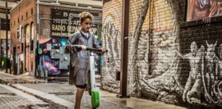 7 Must-Have Features In A High-Performance E-Scooter Boy Standing on Black and White Kick e scooter