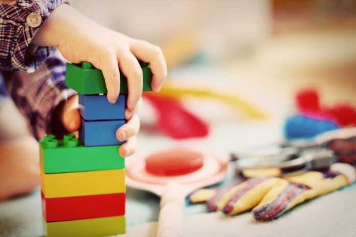 child building with Lego blocks in a daycare business