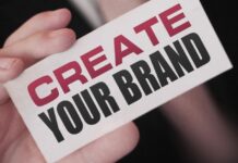 Unraveling The Mysteries of Personal Branding: 8 Most Asked Questions man holding up a create your brand sign - unlocking the mysteries of personal branding