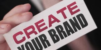 Unraveling The Mysteries of Personal Branding: 8 Most Asked Questions man holding up a create your brand sign - unlocking the mysteries of personal branding