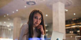 Women in Tech: Celebrating Innovation During Women’s History Month young women in tech at laptop smiling into camera