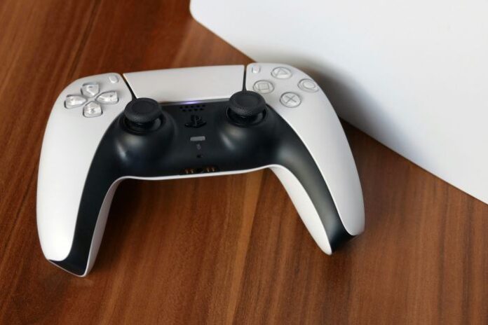 photo of a white and black PlayStation or PS5 controller