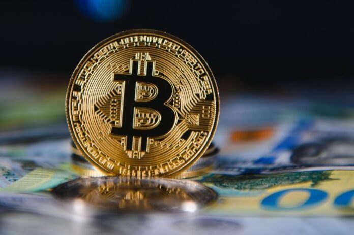photo of a gold coin with the Bitcoin logo on it