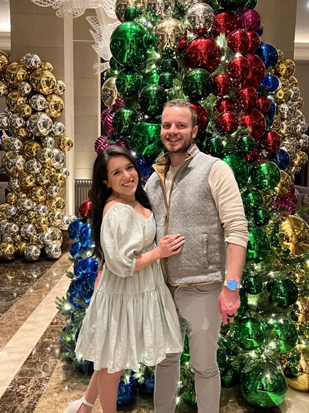 Paul Wnek and his wife in front of a Christmas tree