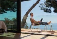 Navigating the Future of Remote Work: Embracing Trends & Technologies the future of remote work with a man sitting outside with his laptop overlooking the ocean