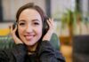 Securing Success: Leveraging Call Recording for Business Growth smiling girl holding her headset to her ears during call recording