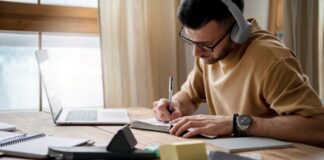 How To Become A Better Business Writer In 3 Easy Steps a business writer writing in his notebook and laptop