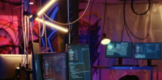 The Main Cybersecurity Trends and Predictions to Watch Closely in 2024 hacker desk with many computers and monitors to thwart cybersecurity practices