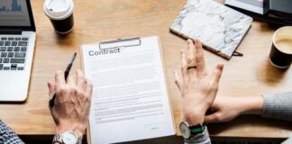 Demystifying Adhesion Contracts: What You Need to Know Before Signing People at desk discussing contract of cohesion.