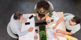 How Nonprofits Can Leverage Project Management Software Nonprofit workers around a table working on new project management software