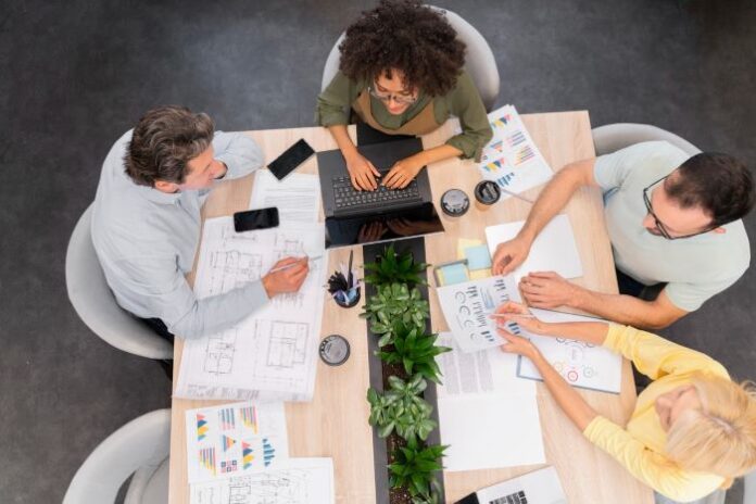 Nonprofit workers around a table working on new project management software