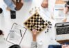 How to Track Competitor Keywords and Improve Your Content Strategy Top view of desk with chessboard, where business owners are using content strategy