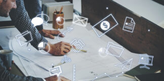 9 Critical Tips for Developing a Comprehensive Marketing Strategy A table with charts and graphs, and two sets of hands of professionals working on marketing strategy