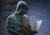 Can Cybercrime Present a Challenge to Your Digital Strategy? a hooded figure committing cybercrime on a laptop, with HTML text in the background