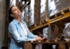 Why an OMS is the Heart of Inventory Management in Retail Operations  Woman in warehouse using a laptop to assess the inventory management