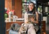 Tips To Help You Thrive as a Small Business Owner A small business owner working on her business sitting at a cafe with a cat