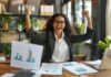 Make Your Business More Efficient and See More Business Success A woman is sitting at a desk with her hands up in the air celebrating business success and the word graph on the top of the desk