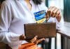 Is Credit Card Insurance Worthwhile? Woman with credit card insurance pulling her cards out of her wallet