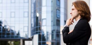 How To Make Decisions in Business Man outside an office building making decisions for his business