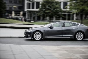 a man driving and thinking about buying a Tesla