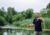 Fishing Apps Transforming Skills of Modern Anglers with New Technology Modern angler in a stream holding a rod and fish