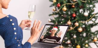 Virtual Holiday Events: Embracing Festive Cheer in the Digital Age woman in front of Christmas tree having a virtual holiday event