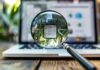 Tips For Improving Website Visibility This Year viewing a laptop through a magnifying glass to show improving website visibility
