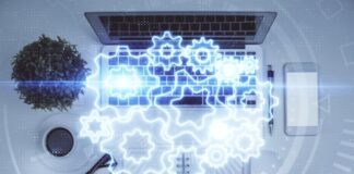 How Dark Processing Boosts Productivity Through Automation graphic of gears over a laptop to show how dark processing boosts productivity