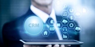 Top Tech Tools Transforming CRM and Sales Automation for Success Man holding device with graphics of CRM to show sales automation