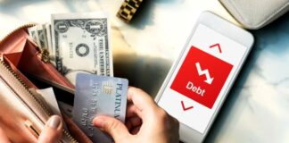 Common Warning Signs of Fraudulent Loan Offers Wallet and phone of person thinking about fraudulent loan offers