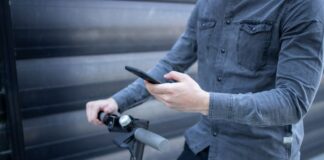 Why Tech-Driven Mobility Solutions Are Gaining Popularity man and tech-driven mobility on his phone and electric bike
