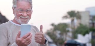 Empowering Seniors: 7 Benefits of GPS Technology GPS device empowering seniors to be independent, shown with elderly man outside giving thumbs up at his phone