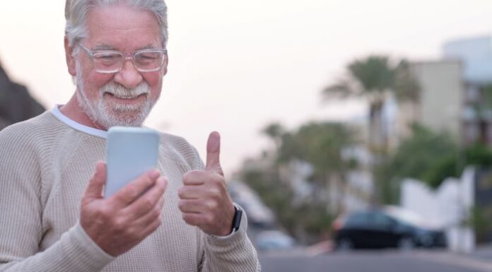 Empowering Seniors: 7 Benefits of GPS Technology GPS device empowering seniors to be independent, shown with elderly man outside giving thumbs up at his phone