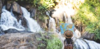 Exploring the Intersection of Technology and Sustainable Travel woman using sustainable travel to see a waterfall