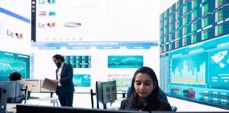 Is Forex Trading Legal in Singapore? Office of Forex trading in Singapore, with big graphs on screens above worker