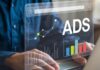 Effectiveness of Ad Exchanges: A Guide for CTOs and Product Managers Ad exchanges shown with person on laptop with ads graphic hovering above