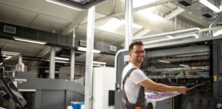 How Your Business Can Improve Sustainability Through Green Printing smiling man doing green printing on industrial printer