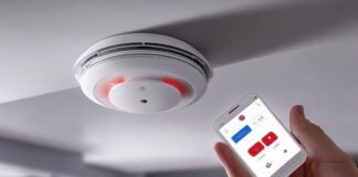 Photoelectric Smoke Alarms – A Must for Every Home woman holding remote to photoelectric smoke alarms