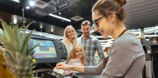 Selecting the Ideal Point of Sale System for Your Business in 2025 point of sale interaction at grocery with checker and family