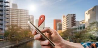 Here’s What Can Happen if You Share Your Location on Social Media share your location on social media, shown with hand holding smartphone with location icon