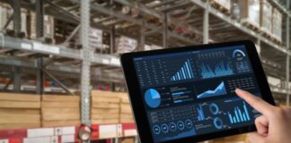 AI in Inventory Optimization: Meeting Consumer Demand Accurately AI in inventory optimization, shown with a hand holding a tablet in a warehouse