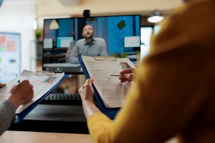 IT job interview with candidate on screen and two recruiters