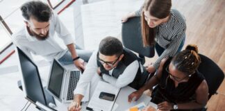 How to Build a High-Performing IT Team from Scratch high-performing IT team, working at a table with laptops