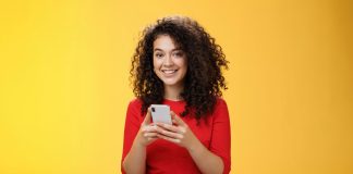 6 Best Tools to Manage WhatsApp Business for Teams girl smiling while showing how to manage whatsapp